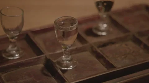 Baijiu Tasting Flight with Clear Spirits in Glasses on Wooden Tray, Beijing Bar Stock Footage 345749786
