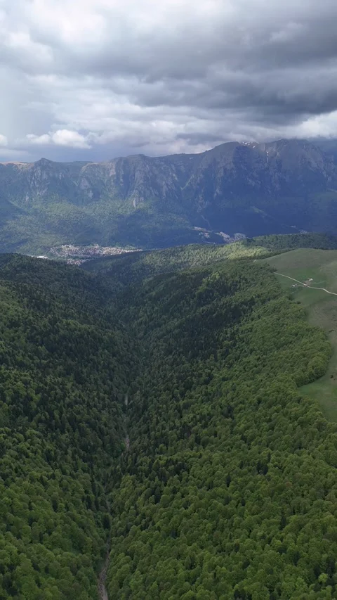 Baiu Mountains forested valley with Bucegi cliffs aerial view Stock Footage 335070790