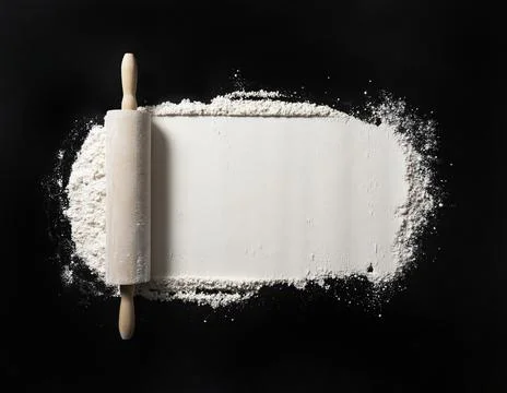 Bake background with free space for text. Rolling pins and flour on a black t Stock Photos
