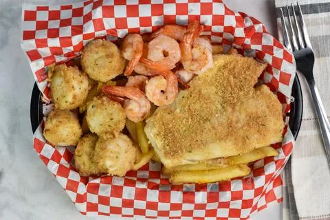 Bake cod with scallops and shrimp served with fries Stock Photos
