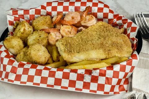 Bake cod with scallops served with  shrimp and fries Foto stock