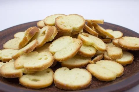 Bake Rolls. The mini bread chips on the brown bowl. Isolated on white backgro Stock Photos