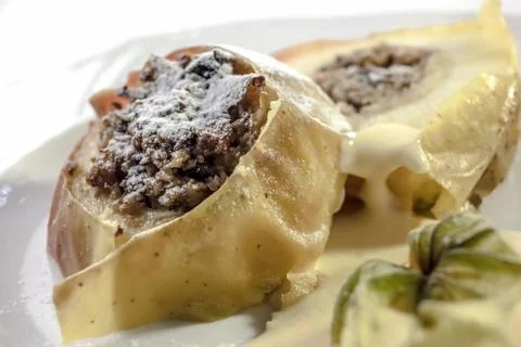 Baked apples stuffed with a mixture of nuts and raisins, on vanilla sauce Stock Photos