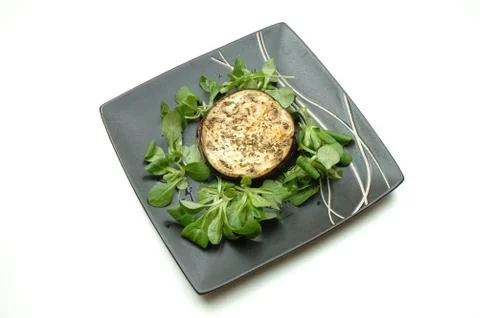 Baked Aubergine with rocket salad on black plate Stock Photos
