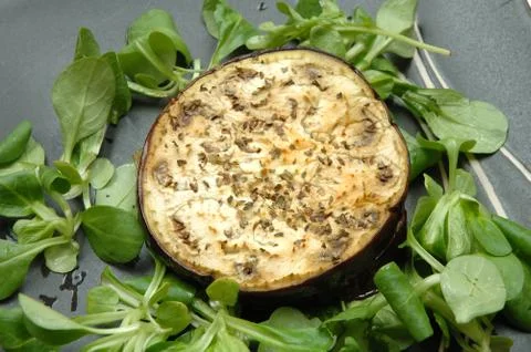 Baked Aubergine with rocket salad on black plate Stock-Fotos