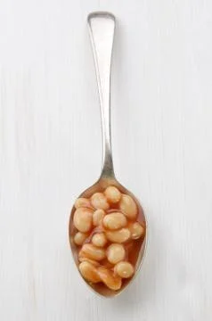 Baked beans on a spoon Stock Photos