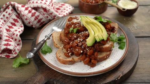 Baked beans on toast with cilantro, adding cheese on top the sandwich Stock Footage 242530807