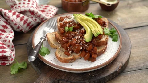 Baked beans on toast with cilantro and avocado Stock Footage 242530939