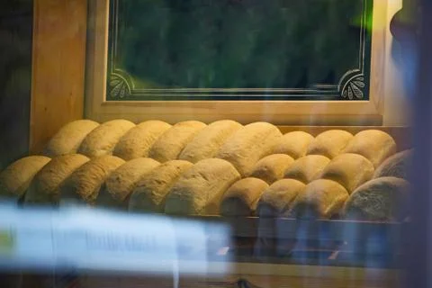 Baked bread in a bakery window display. Baked bread closeup in a typical conf Stock Photos