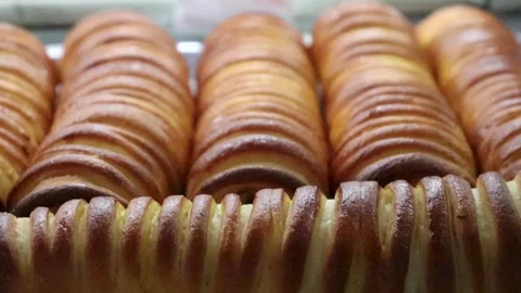 Baked bread rolls macro video showing uniform cylindrical loaves with warm Stock Footage 338164598