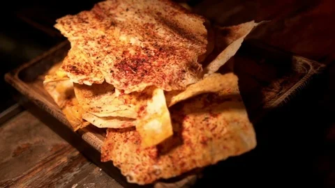 Baked bread snacks with spices and tomatoes on wooden cutting board, close-up Stock-Footage 83425725