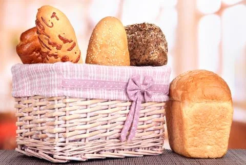 Baked bread in wicker basket on window background Stock Photos
