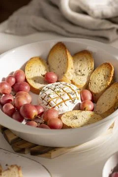 Baked brie cheese with bread and grapes Stock Photos