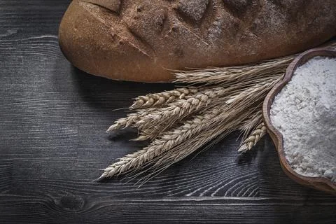 Baked brown bread Wheat rye ears Wooden bowl with flour on wooden board 스톡 사진
