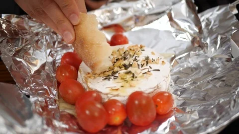 Baked Camembert, being dipped with bread in slow motion. Stock Footage 109533534