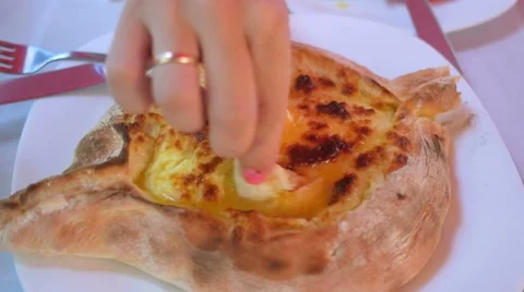 Baked cheese biscuit with egg and butter. Girl with bright manicure dunks a Stock Footage 67511932