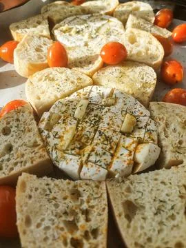 Baked cheese with bread and cherry tomatoes, homemade appetizer Stock Photos