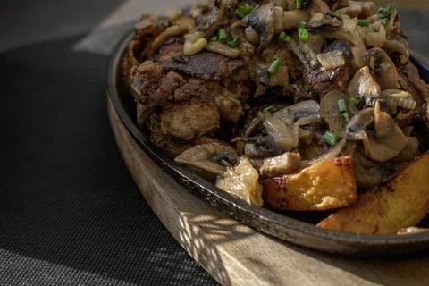 Baked chicken livers and potatoes with garlic, herbs, and fried onion in a .. Stock Photos