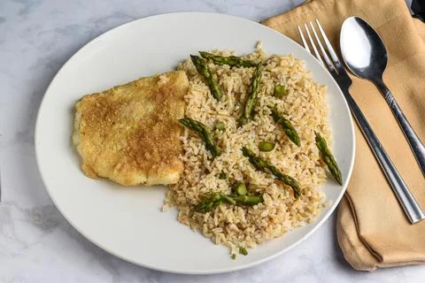 Baked cod  with brown rice  and asparagus Stock Photos
