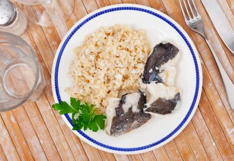 Baked cod fillets with basmati rice and fresh parsley Stock Photos