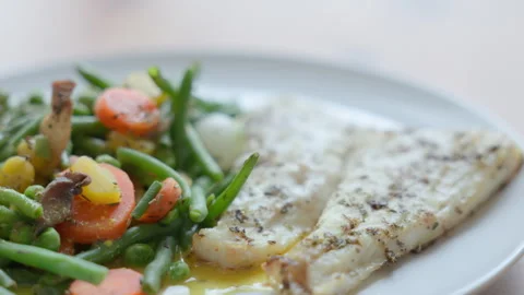 Baked Cod Fish Fillet Served with Steamed Green Vegetables Stock Footage 322016269