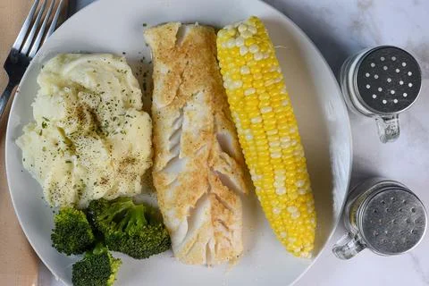Baked cod served with  corn and mashed potatoes Stock Photos