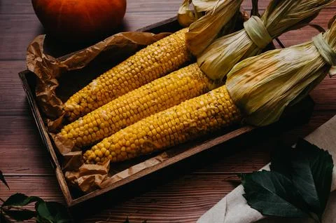 Baked corn in a dish on the table in close-up. Stock Photos