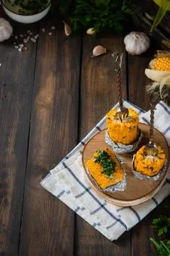 Baked corn with spiced butter on a rustic wooden background. Barbecue food. T Stock Photos