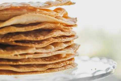 Baked crumpets cakes made of puff pastry for layer cake on a glass stand. Stock Photos