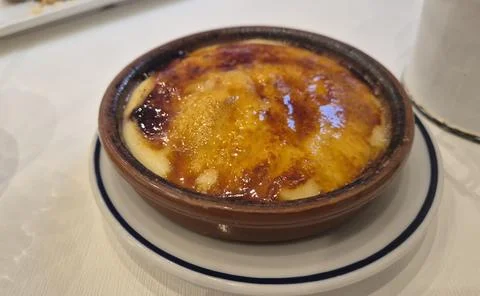 Baked custard dessert in rustic ceramic dish Stock Photos