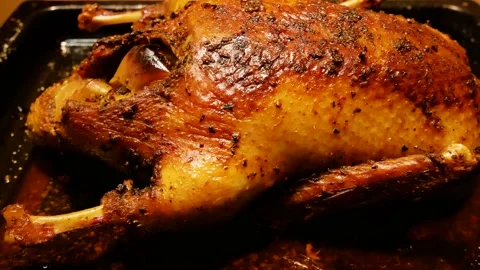 Baked duck carcass on a baking sheet with a ruddy crust. Inside the duck are Stock Footage 229545872