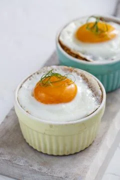 Baked eggs in ramekins close view, selective focus Stock Photos
