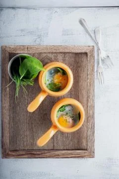 Baked eggs with spinach Stock Photos