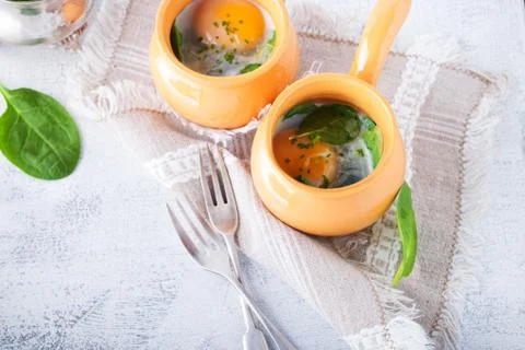Baked eggs with spinach Stock Photos