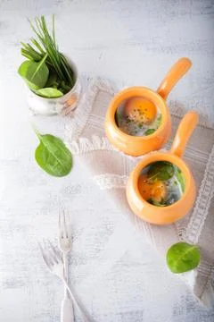 Baked eggs with spinach Stock Photos