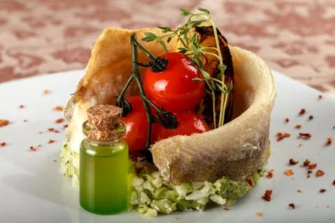 Baked fish on a vegetable side dish with cherry tomatoes. 스톡 사진