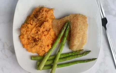 Baked haddock served with  mashed sweet potatoes Foto stock