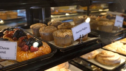 Baked items in bakery display window labels assorted muffins variated scones Video stock 89358824