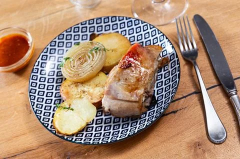 Baked lamb chops with roasted potatoes, onions and sauce Stock Photos