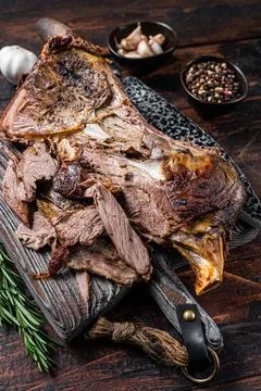Baked lamb mutton cutting shoulder meat on a wooden board. Dark wooden Stock Photos