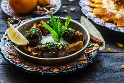 Baked lamb shanks middle eastern style in copper pan Stock Photos