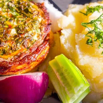 Baked meat with cheese and mashed potatoes with fresh vegetables as a side dish Stock Photos