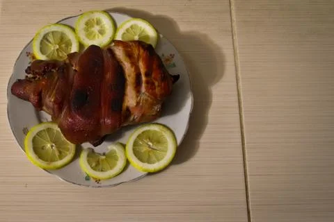 Baked meat flavored with lemon on a platter. Stock Photos