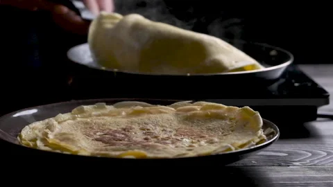 Baked pancake on foreground, flipping over pancake on background slow motion Stock Footage 169237221