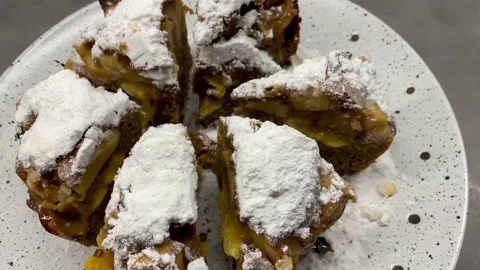 Baked pie dusted with powdered sugar and cut into wedges on a white plate Stock Footage 312999518