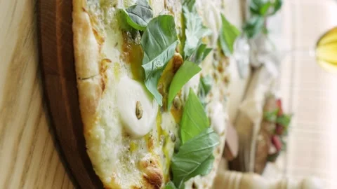Baked pizza with sausage, vegetables and olives. butter is poured on the pizza Stock-Footage 148005341