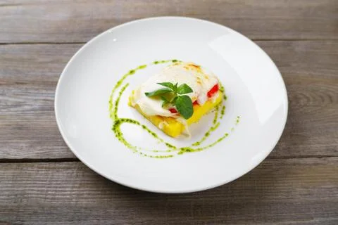 Baked polenta with cheese, tomato and pesto sauce Stock Photos