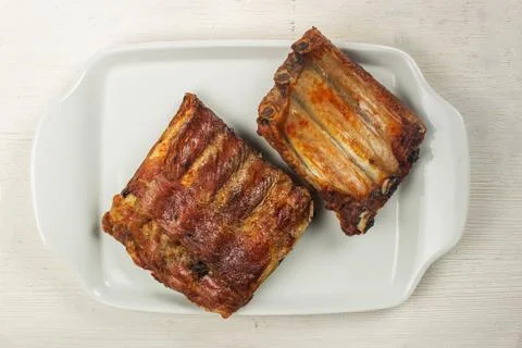Baked pork ribs on a white plate, top view Stock Photos