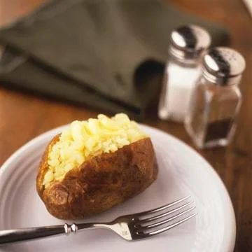 Baked Potato Split with Butter Stock Photos