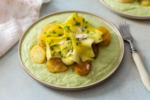 Baked potatoes are topped with slices of fermented zucchini and served alongs Stock Photos